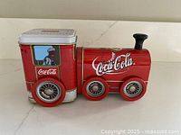 Side view showing Coca-Cola logo, driver image, wheel detail