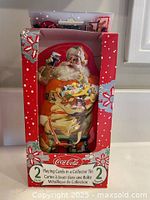 Front of unopened box showing Santa tin and playing card decks