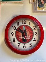 Front view of Coca-Cola wall clock showing dial design and numerals