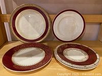 Front view of four burgundy and gold plates