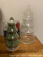 Two glass tree containers with crushed glass bottles behind