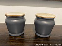 Pair of grey jars with wood lids, front view