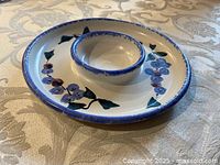 Angled view showing plate with attached dip bowl and painted design