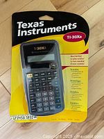 Front view of sealed Texas Instruments TI-30Xa calculator in retail packaging