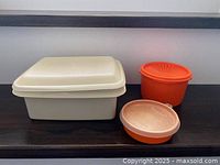 Three Tupperware containers with lids displayed