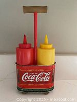 Front view of Coca-Cola metal stand with red and yellow squeeze bottles
