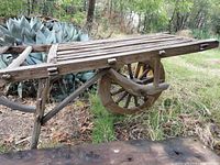 Full side view showing slatted bed, single wooden wheel, frame