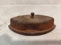 Top view showing ASBESTOS SAD IRON lettering and handle stud