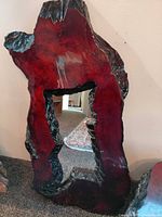 Live-edge driftwood wall mirror with reddish finish and central beveled glass