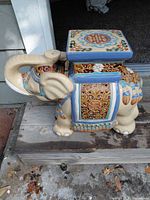 Left side view of ceramic elephant plant stand with square top