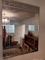 Full view of rectangular etched wall mirror mounted on wall