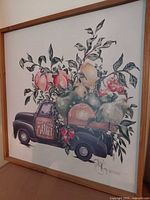 Square framed art showing vintage truck carrying fruit, light wood frame
