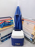 Group shot of all items: three folded chairs, Igloo cooler, umbrella