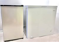 Frigidaire upright refrigerator beside Midea chest freezer, closed view