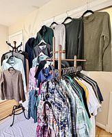 Full view of shirts and sweaters on hangers and rack
