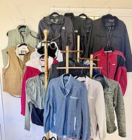 Group shot of all jackets, vests and fleeces on coat rack