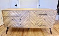 Front view of six-drawer dresser showing herringbone veneer and black pulls