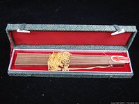 Fan folded inside brocade box showing tassel