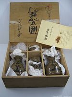 Box opened showing compartmented interior with tokkuri and cups wrapped