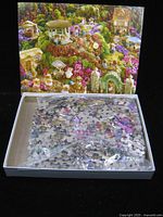 Open box showing sealed bag of puzzle pieces and lid image
