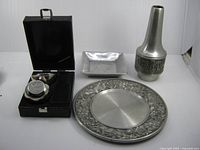 Group shot showing all four pewter items: Boma plate, square dish, shot glasses in case, Norse Tinn vase