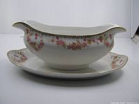 Side view of gravy boat showing floral pattern and attached plate