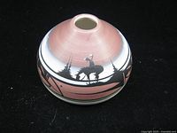 Front view of squat ceramic vase showing pink body, painted deer and landscape motif