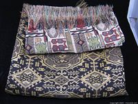 Folded tablecloth and folded runner showing patterns and fringes