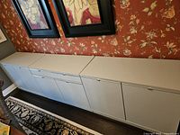 Front view of entire modular sideboard showing three cabinets aligned under artwork