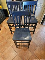 Front view of three navy solid pine bar chairs