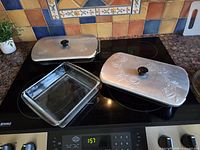 All three glass baking dishes shown on stovetop
