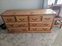 Front view of solid pine dresser showing eight drawers and black metal pulls