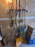 Full view of rack holding long-handled tools plus snow shovel at bottom