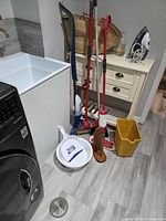 Overall view of cleaning tools grouped beside laundry sink