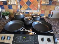 Full set of pots, pans and lids on stovetop