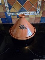 Tagine assembled showing conical lid with black motif on stovetop