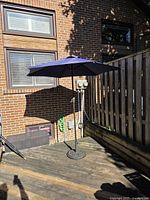 Full view of umbrella opened on deck with stand visible