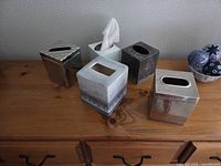 five tissue box covers on dresser top