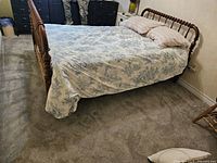 Full view of maple spindle bed with bedding