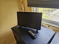 Front view of TV on stand with remote