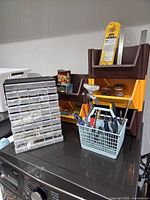 Overview showing hardware cabinet, tiered organizer, hand tools in basket, hammer, level, square