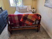 Both plaid mohair throws draped over bed footboard