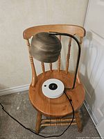 Full view of lamp showing brass shade, black arm, white base, power cord