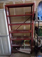 Front view of red metal shelving unit showing full height and shelf arrangement