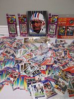 Wide view of loose cards spread out with sealed packs and oversized card