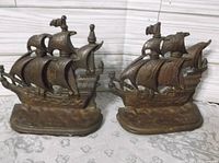 Front view of both cast iron galleon bookends showing design and patina