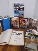 Group shot showing all eight military themed books upright and open