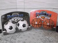 Front of both packaged speaker sets showing soccer and basketball designs