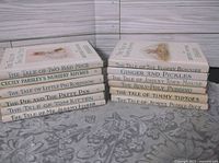 Front view of all 12 Beatrix Potter books stacked showing dust-jacket spines and titles