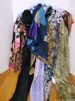 Group of scarves displayed on hanger, showing variety of colours and fabrics